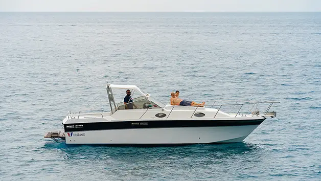 Luxury Wellcraft 3300 motor yacht cruising along the Amalfi Coast cliffs during a private boat charter