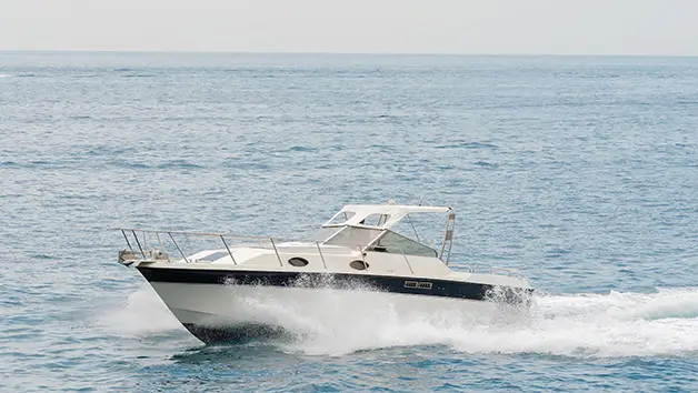 Exclusive sunset boat tour on a Wellcraft 3300 cruiser with the Amalfi coastline in the background
