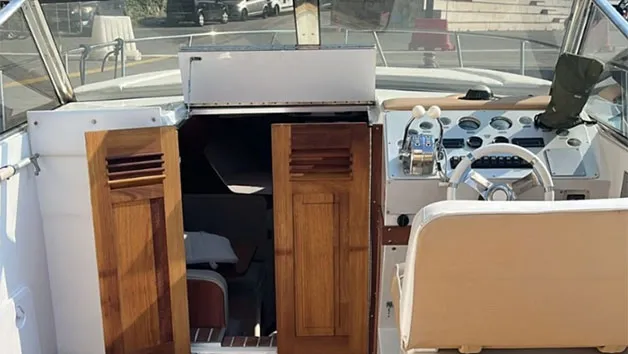 High-angle view of the detailed helm station and open cabin companionway doors on a Wellcraft 3300