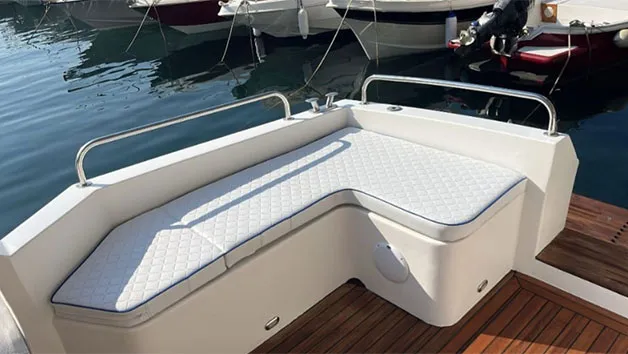 An L-shaped white vinyl bench with diamond stitching provides aft seating on the teak-decked cockpit of a Wellcraft 3300